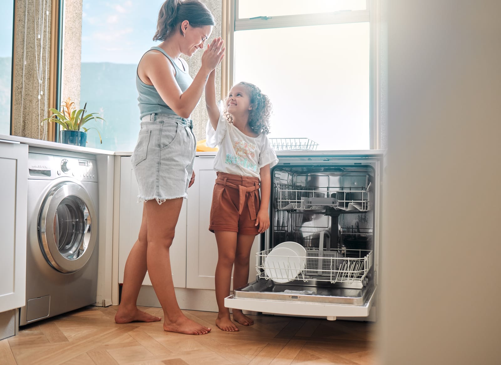 Mother kid or dishwasher in kitchen with high five